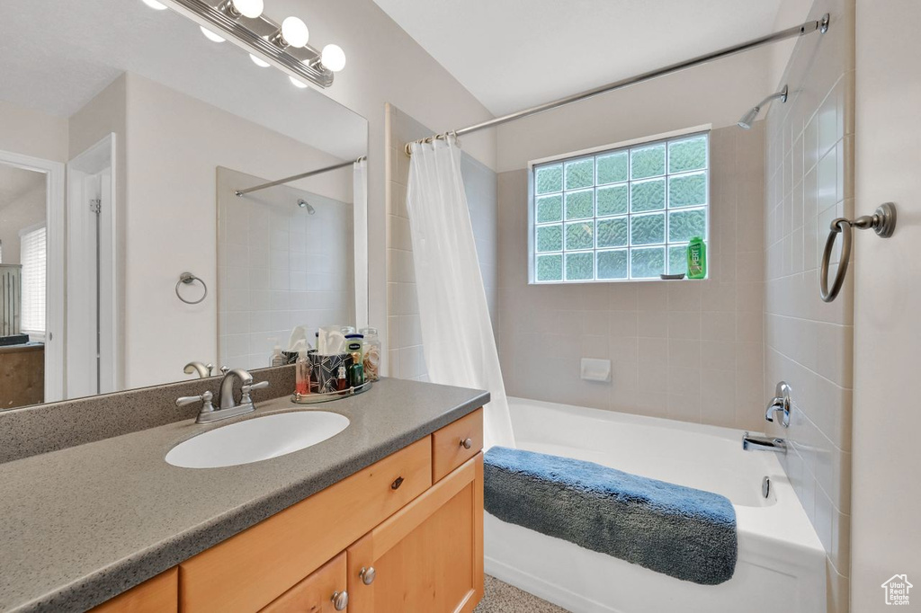 Full bath with shower / bath combination with curtain and vanity