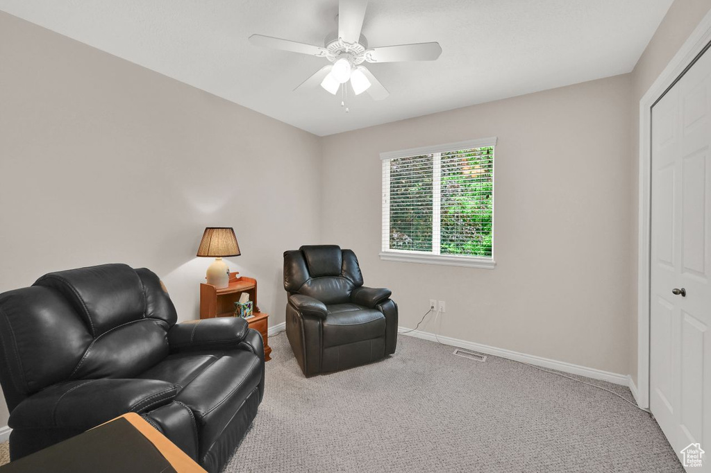 Living area with carpet, baseboards, and ceiling fan