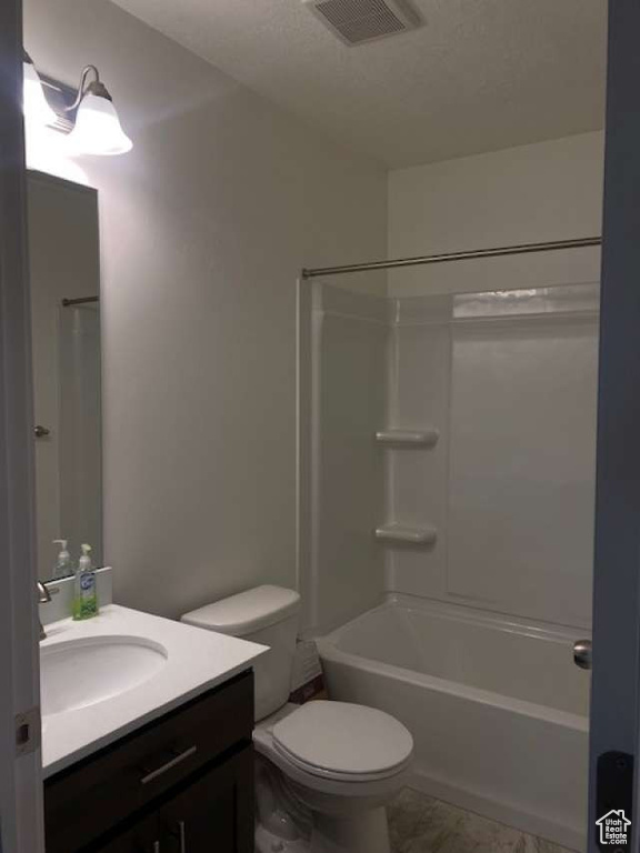 Full bath with vanity, marble finish flooring, toilet, and washtub / shower combination
