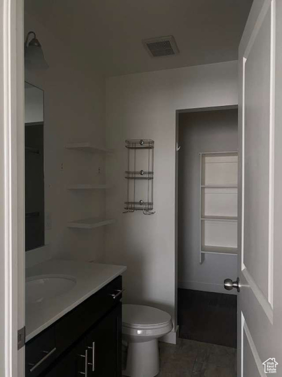Bathroom with vanity, toilet, and baseboards