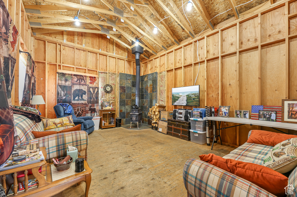 Living area with a wood stove and high vaulted ceiling