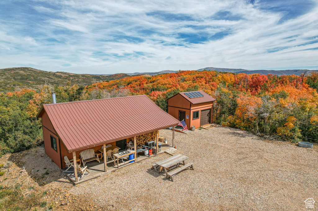 View of subject property featuring a forest and a mountain backdrop