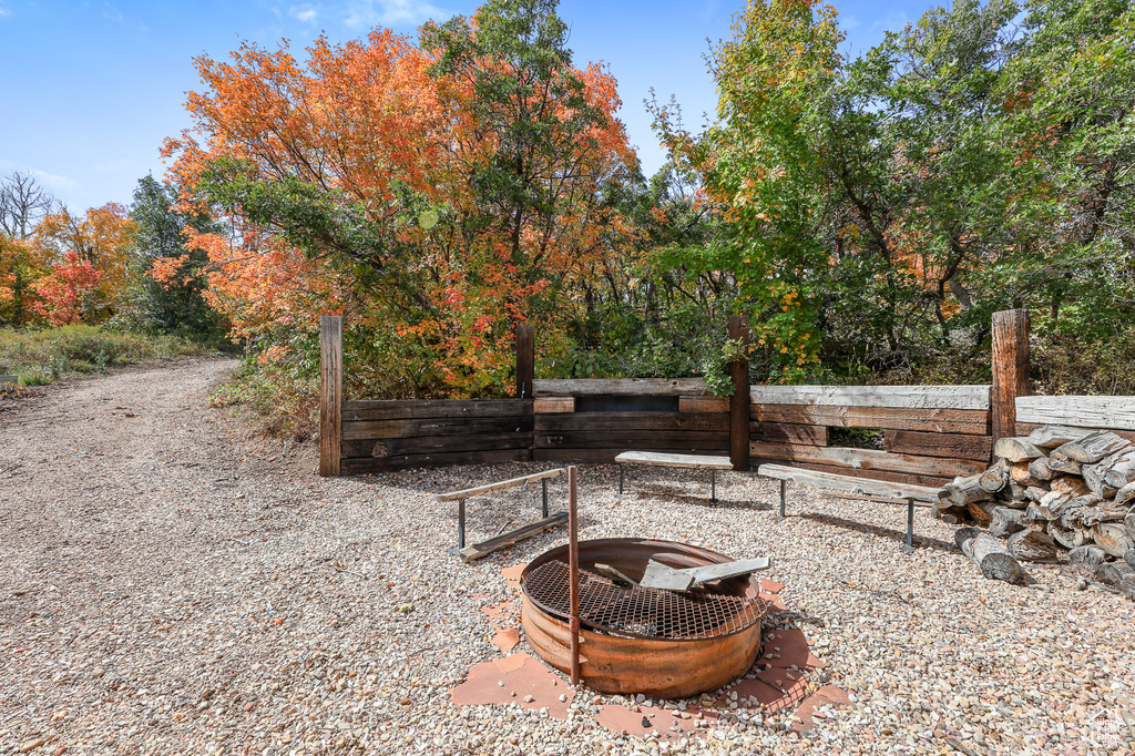 View of yard with an outdoor fire pit and fence