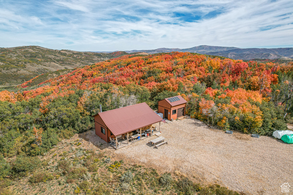 View from above of property with a heavily wooded area and mountains