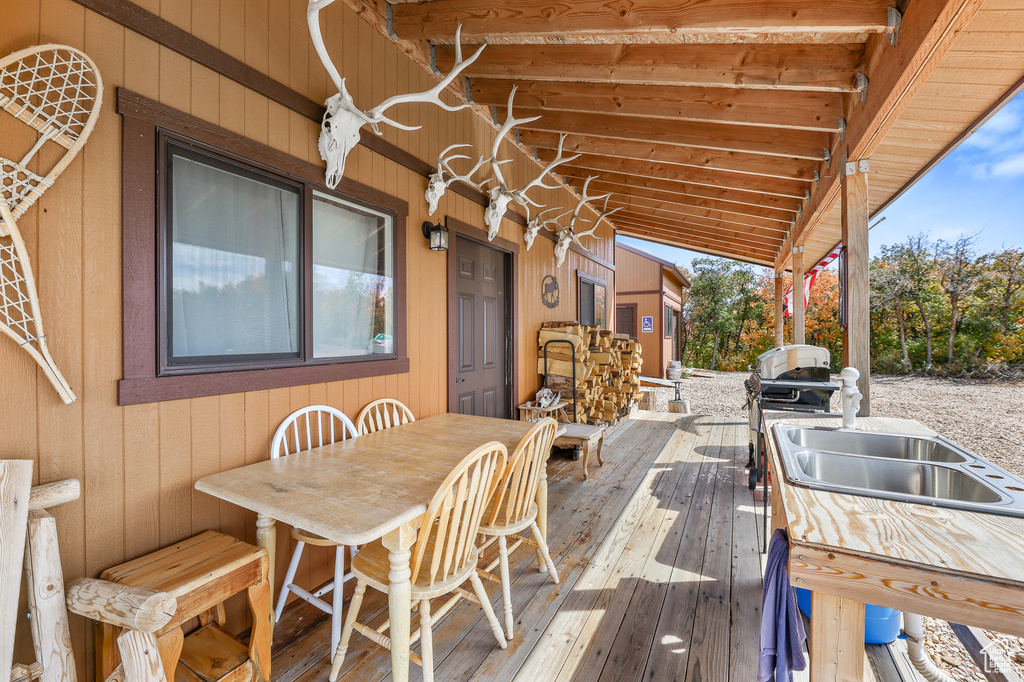 Wooden terrace with a sink and outdoor dining space