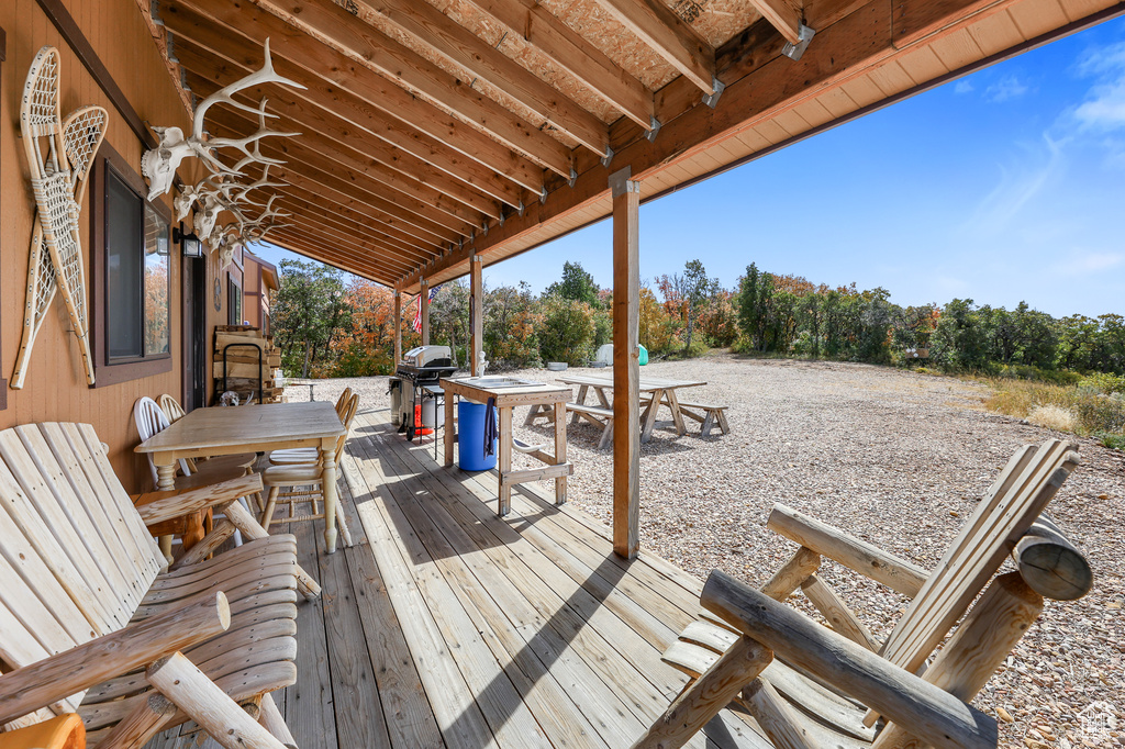 Wooden terrace featuring outdoor dining area and grilling area