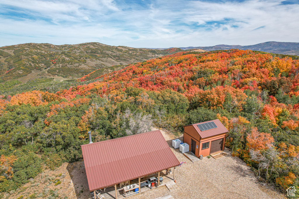 View from above of property with a heavily wooded area and a mountain backdrop