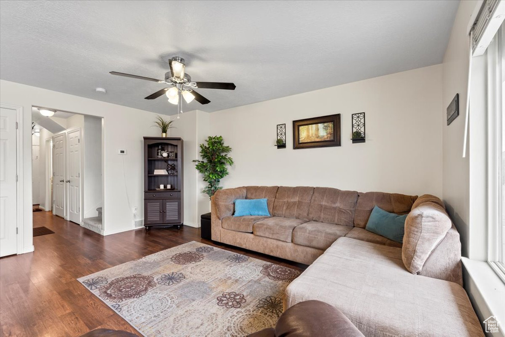 Living area with wood finished floors, a ceiling fan, and baseboards