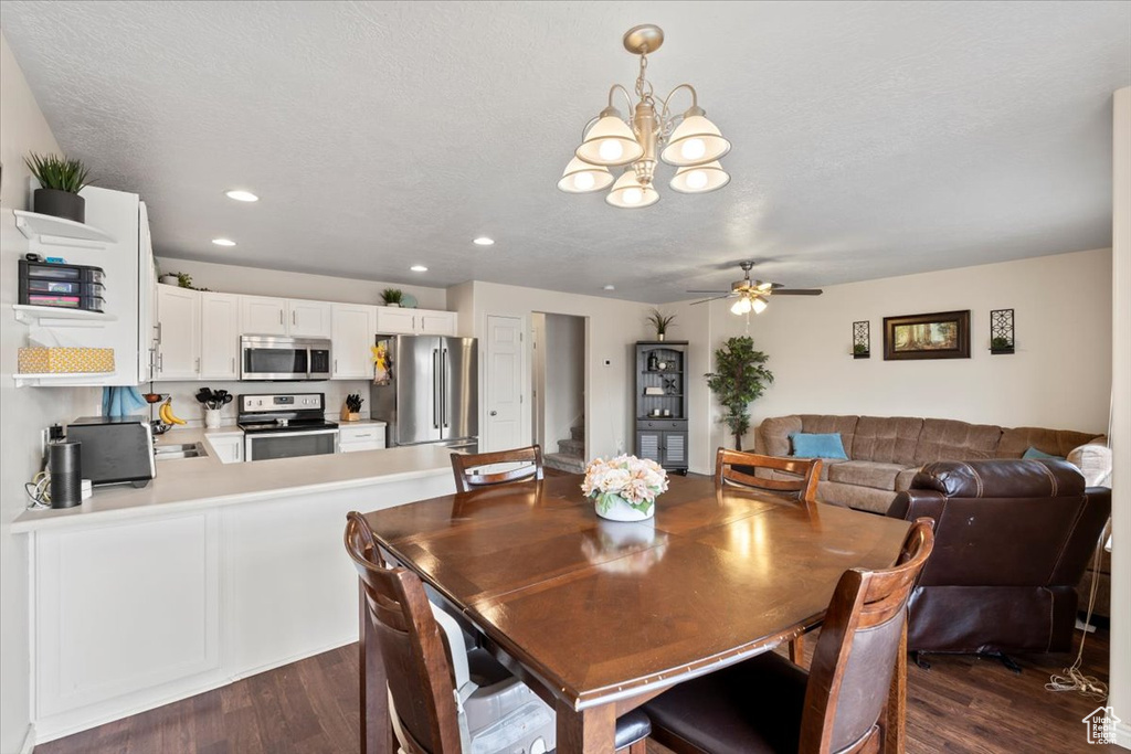 Dining room featuring dark wood-style flooring, a chandelier, ceiling fan, and recessed lighting