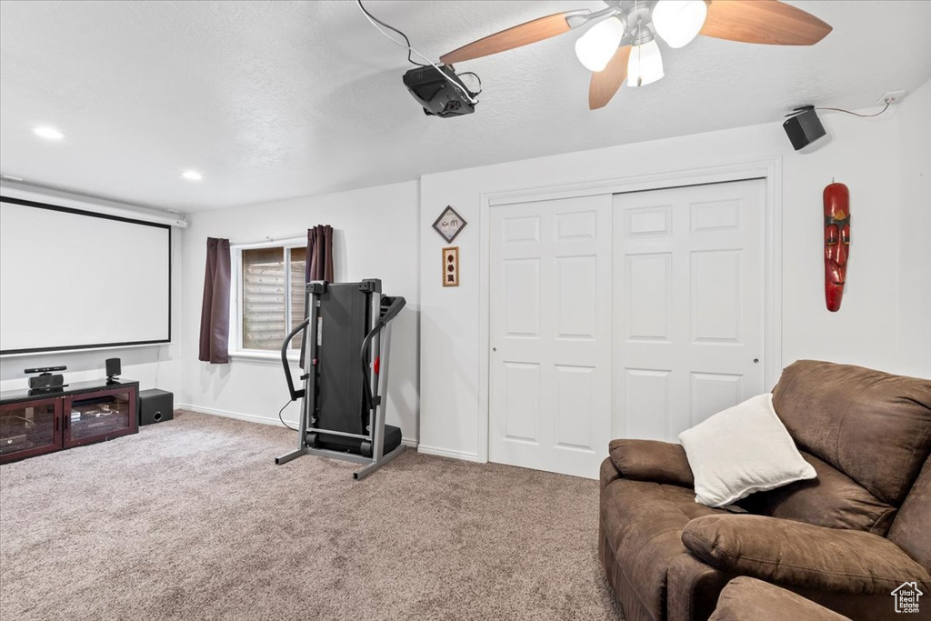 Cinema room with carpet floors, baseboards, and ceiling fan
