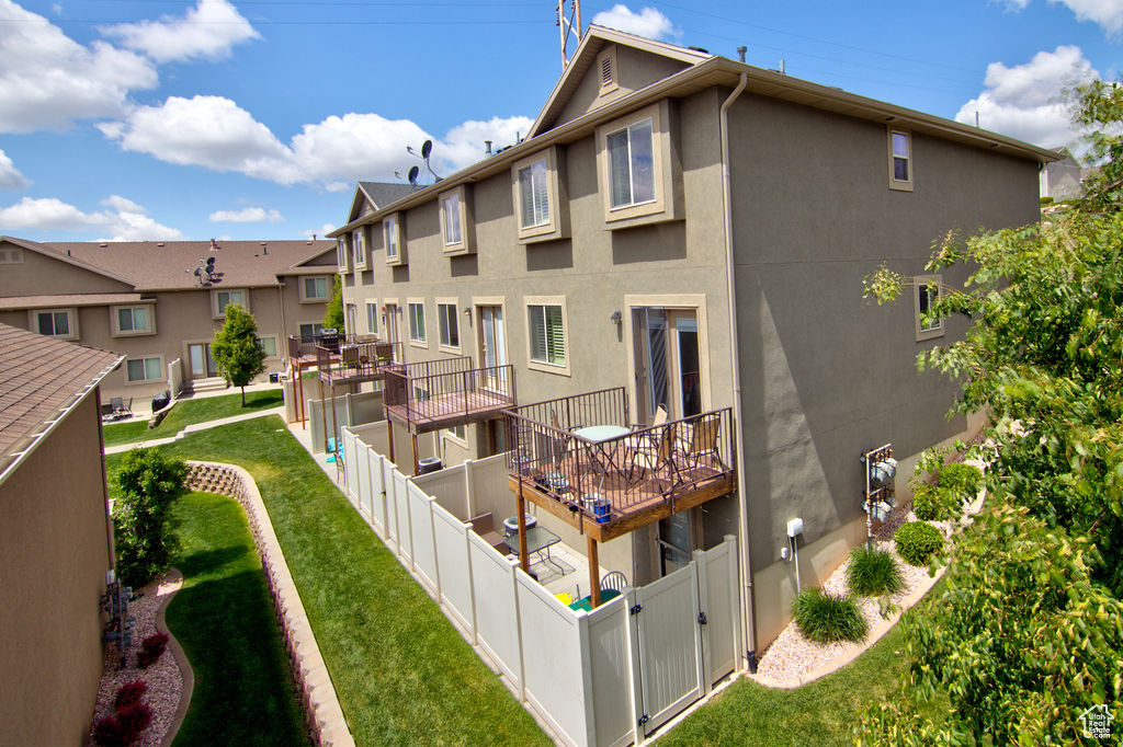 Back of house with stucco siding, a gate, and a residential view