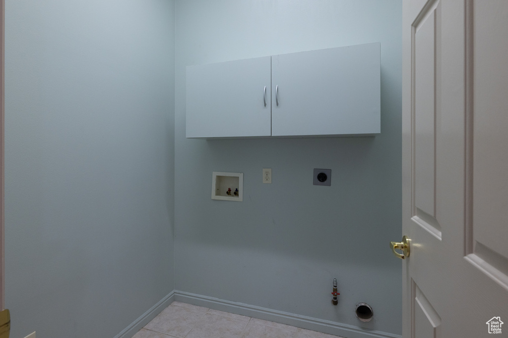 Laundry room with washer hookup, electric dryer hookup, hookup for a gas dryer, baseboards, and light tile patterned floors