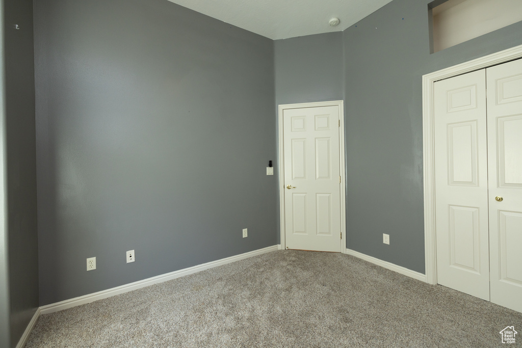 Unfurnished bedroom featuring carpet flooring, baseboards, and a closet