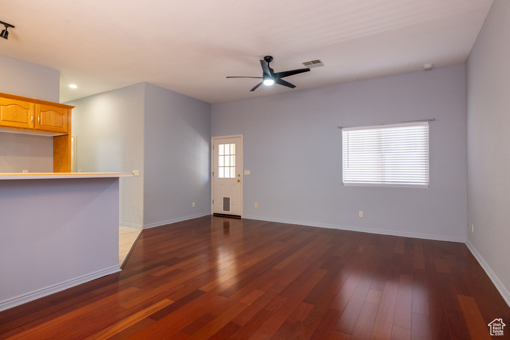 Unfurnished living room featuring dark wood-type flooring, ceiling fan, baseboards, and recessed lighting