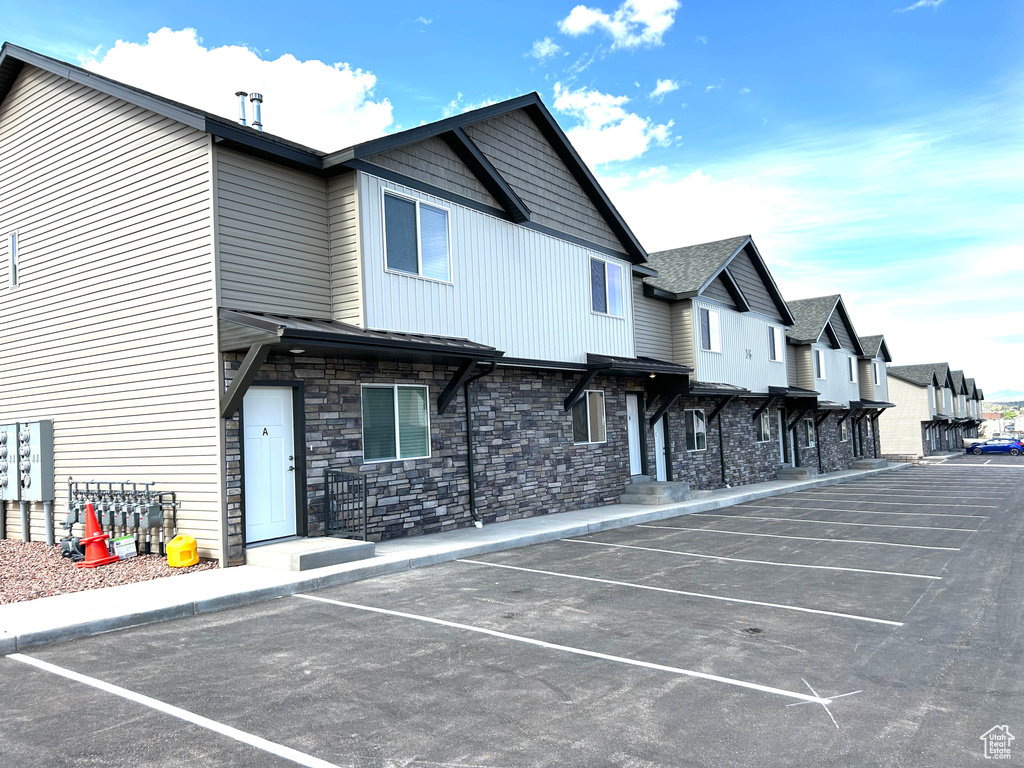 View of building exterior featuring uncovered parking and a residential view