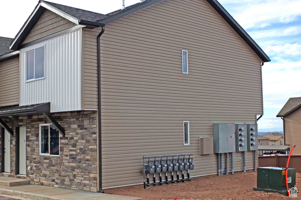 View of home's exterior with stone siding and cooling unit