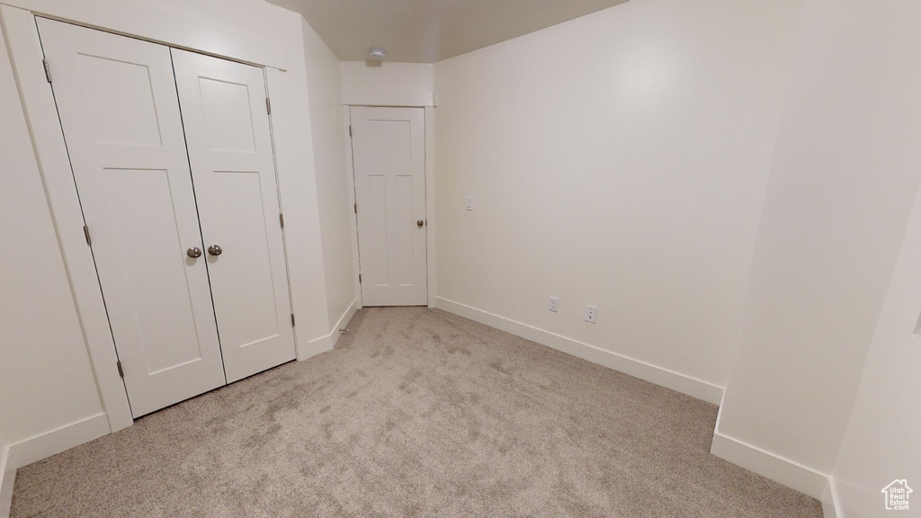 Unfurnished bedroom with carpet flooring, baseboards, and a closet