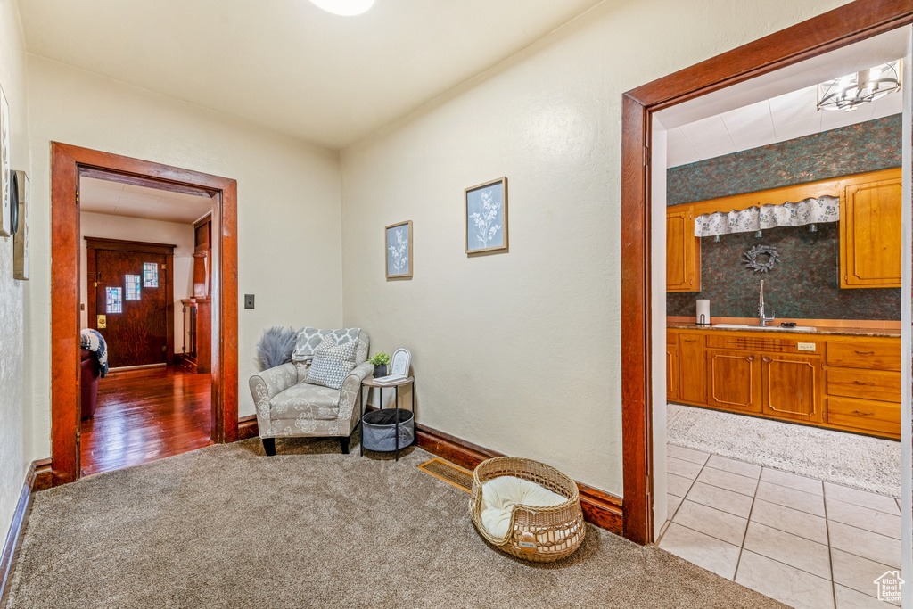 Sitting room with carpet flooring, baseboards, and tile patterned flooring