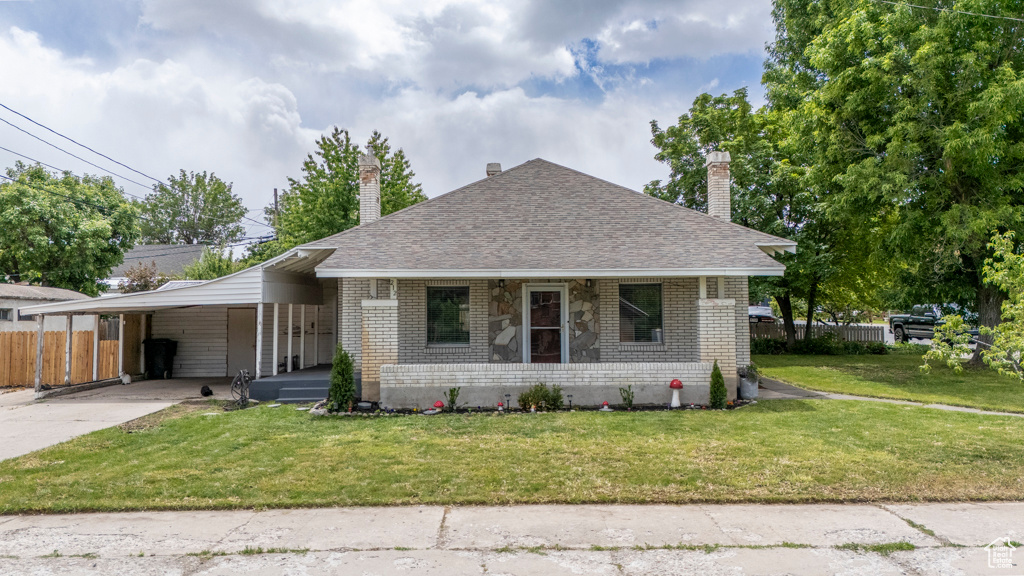 Bungalow-style house with brick siding, covered porch, and a chimney