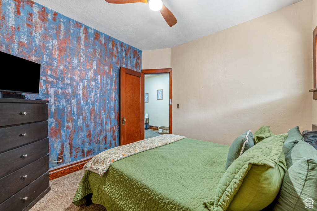 Carpeted bedroom with a ceiling fan