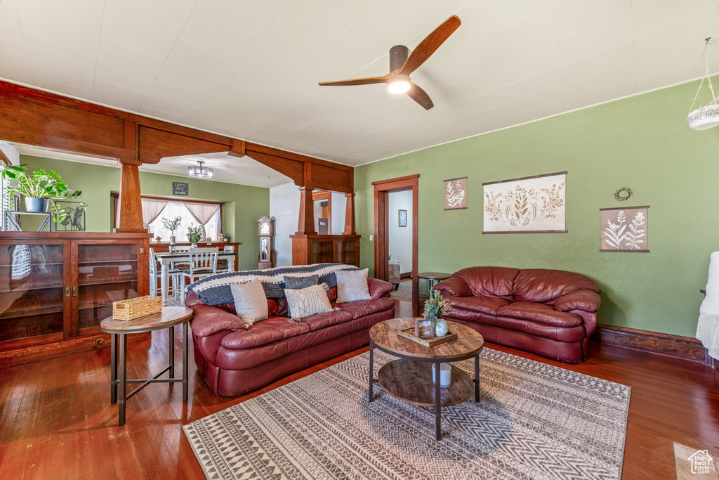 Living room featuring ceiling fan, wood-type flooring, baseboards, and ornate columns