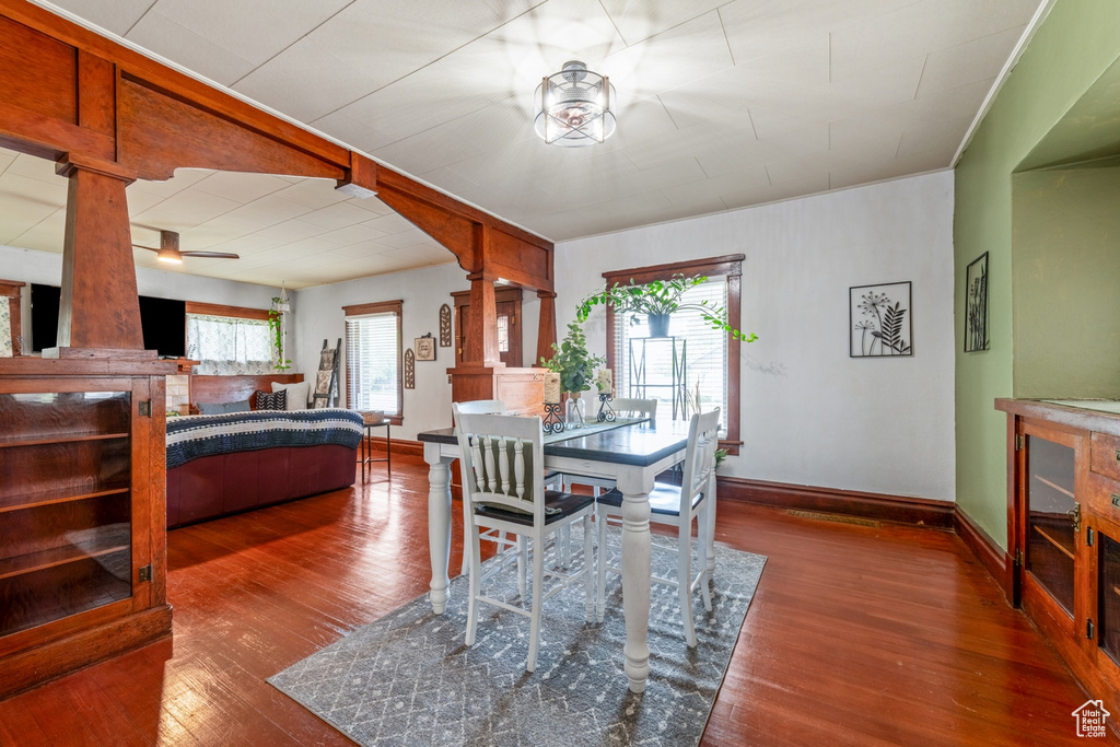 Dining space featuring a ceiling fan, hardwood / wood-style flooring, decorative columns, and baseboards