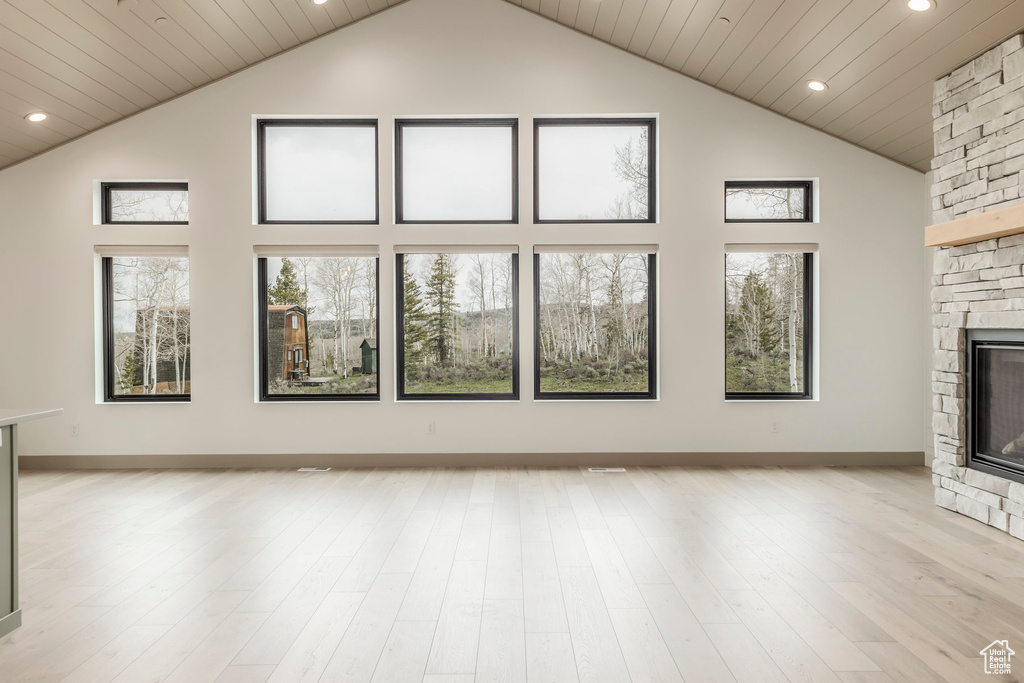 Unfurnished living room with a fireplace, high vaulted ceiling, recessed lighting, light wood finished floors, and wood ceiling