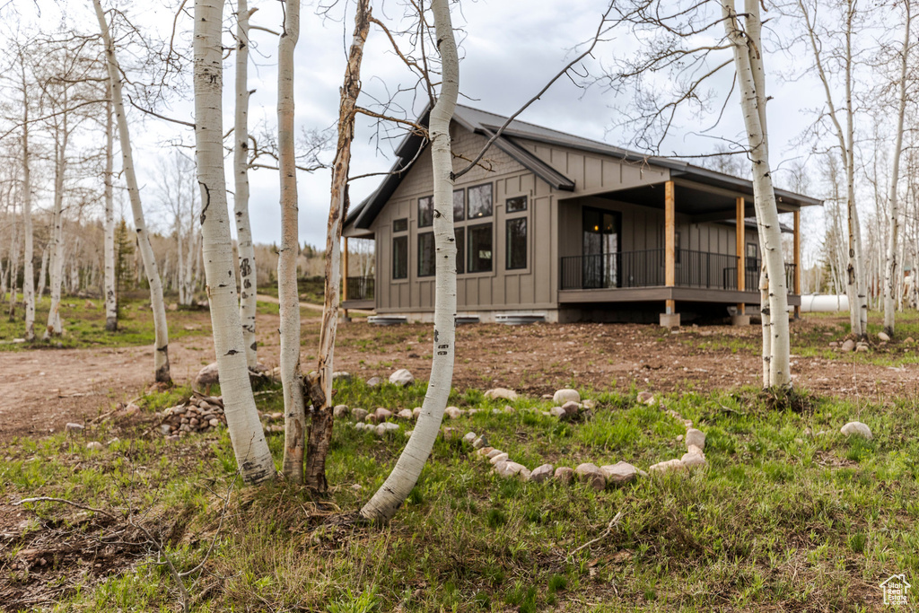 View of side of home with board and batten siding and a porch