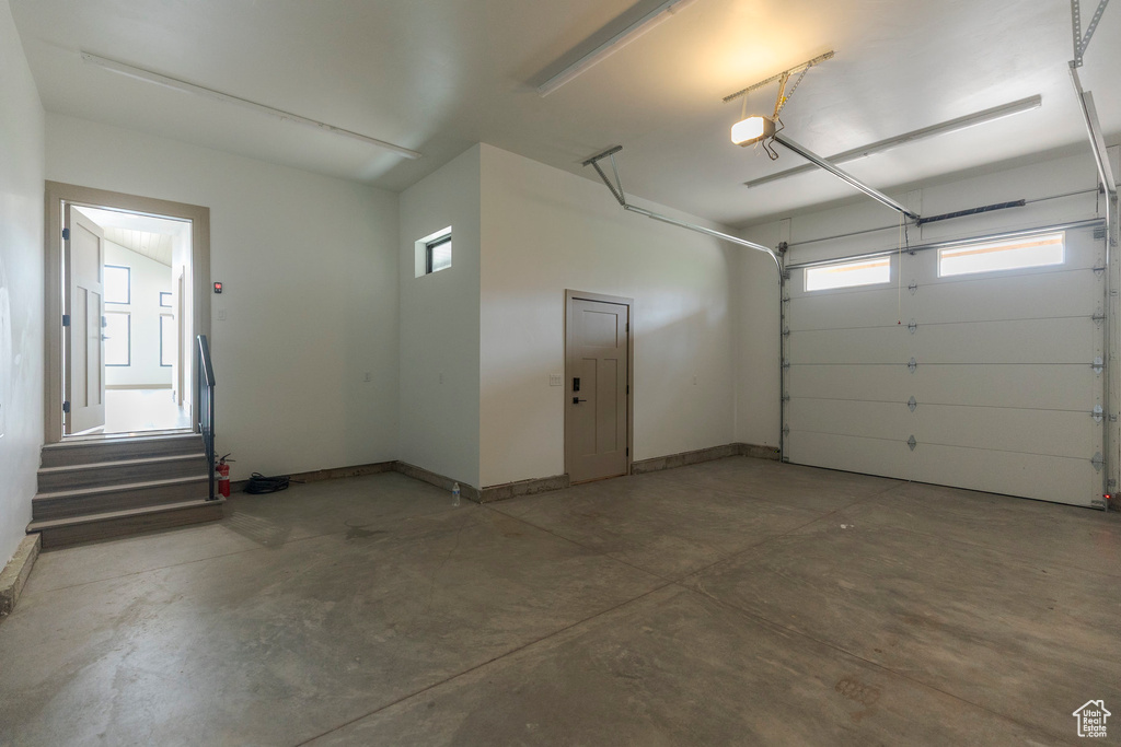Garage featuring a garage door opener and baseboards