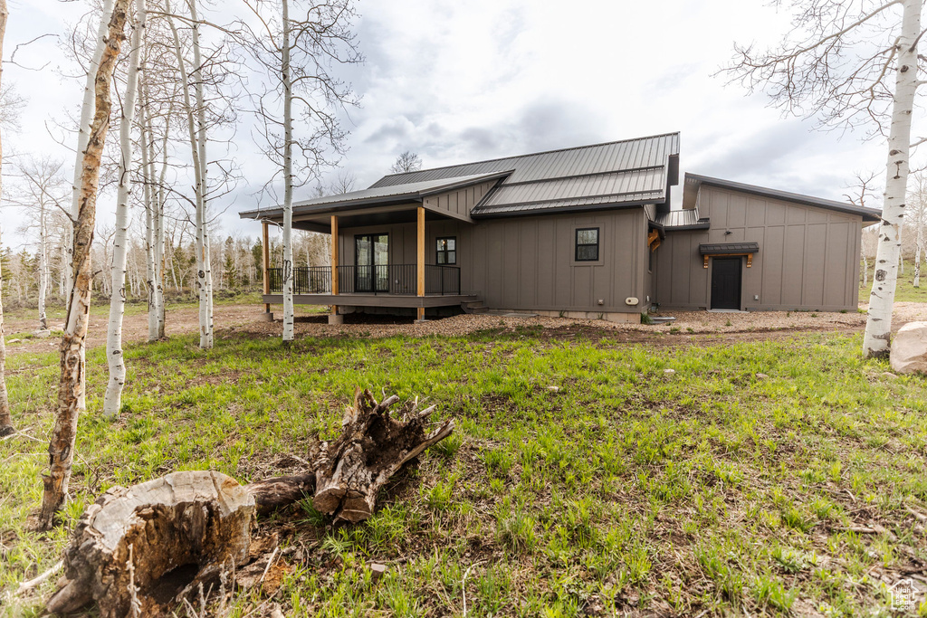 Rear view of property featuring board and batten siding and metal roof