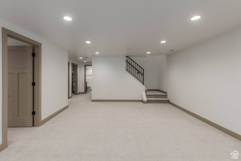 Finished basement featuring recessed lighting, light colored carpet, baseboards, and stairway