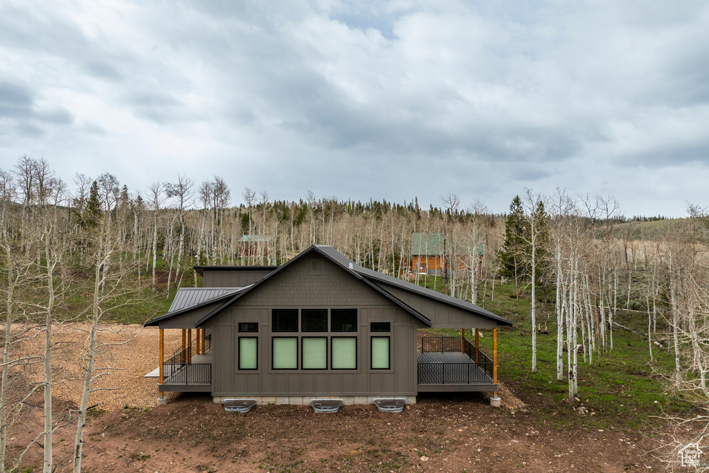 Back of house with a wooded view