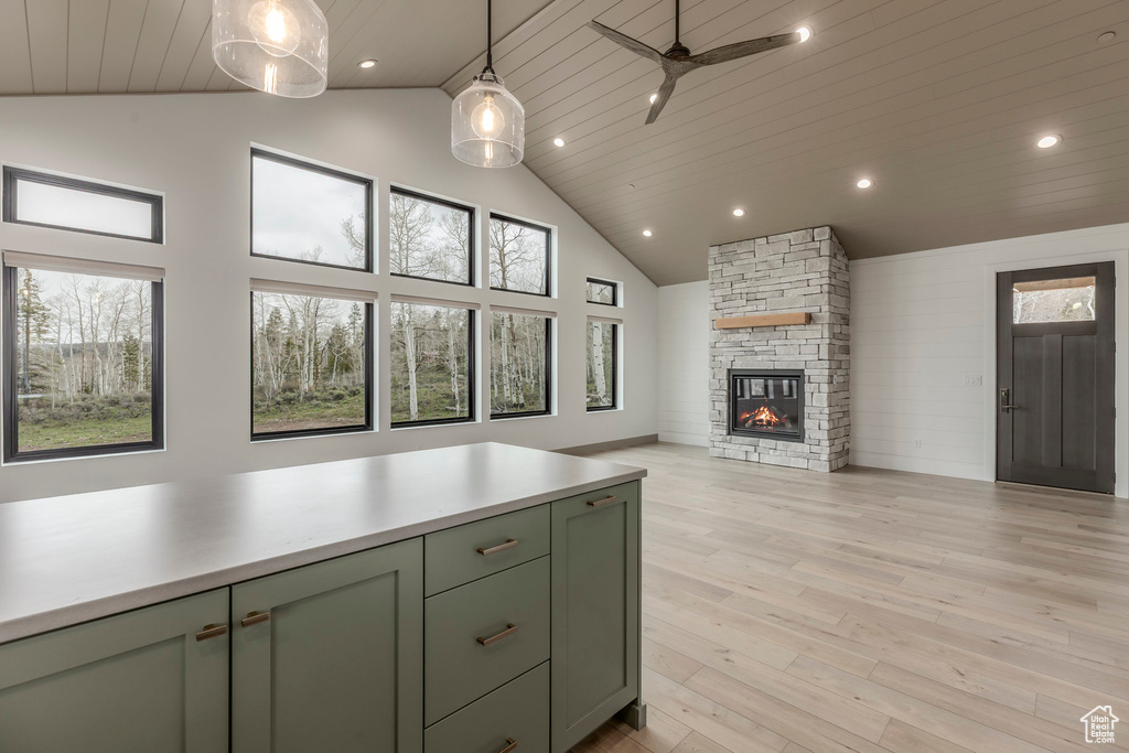 Kitchen with green cabinetry, high vaulted ceiling, plenty of natural light, open floor plan, and recessed lighting