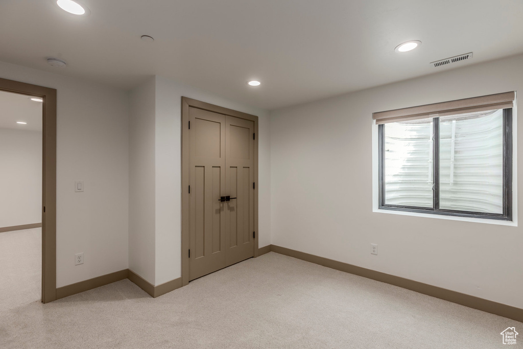 Unfurnished bedroom with light colored carpet, baseboards, recessed lighting, and a closet