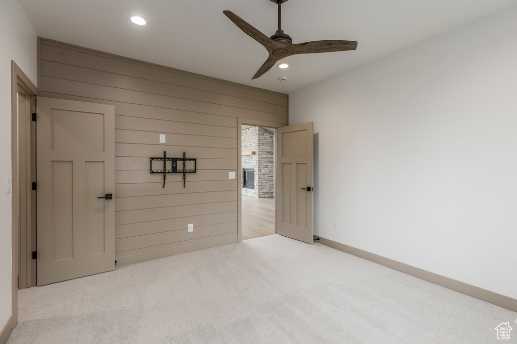 Unfurnished bedroom with carpet floors, recessed lighting, wooden walls, baseboards, and a ceiling fan
