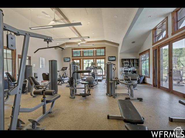 Workout area featuring french doors, a ceiling fan, and vaulted ceiling