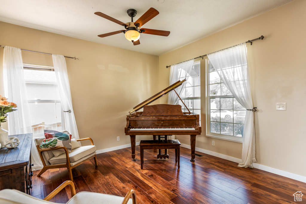 Living area with a ceiling fan, hardwood / wood-style floors, and baseboards