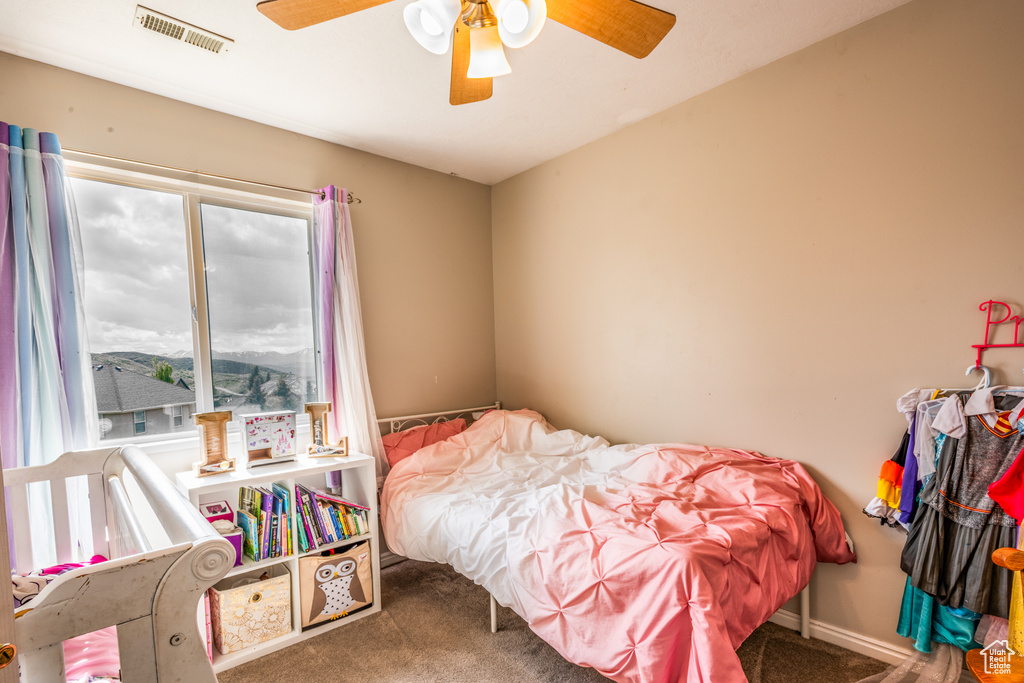 Carpeted bedroom featuring a ceiling fan