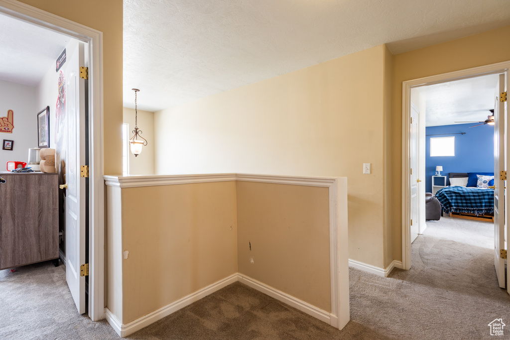 Corridor featuring carpet flooring, baseboards, and an upstairs landing
