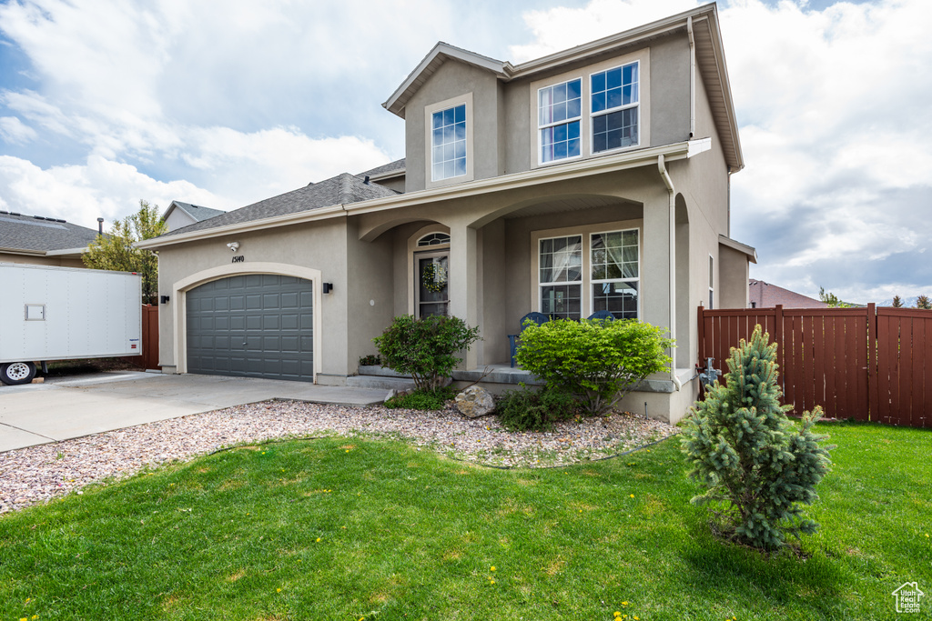 Traditional-style home featuring stucco siding, concrete driveway, an attached garage, and covered porch