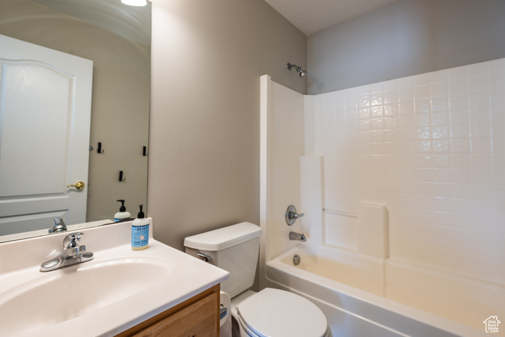 Bathroom featuring toilet, vanity, and  shower combination