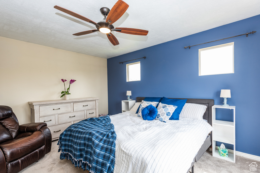 Carpeted bedroom featuring a ceiling fan