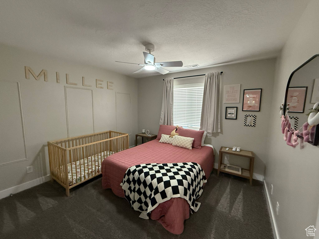 Carpeted bedroom featuring baseboards, a ceiling fan, and a textured ceiling