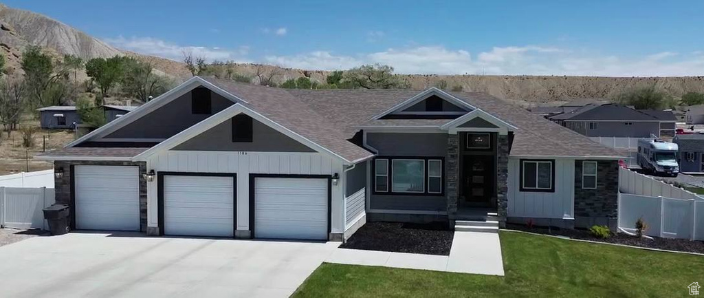 View of front of property with driveway, a garage, and a mountain view