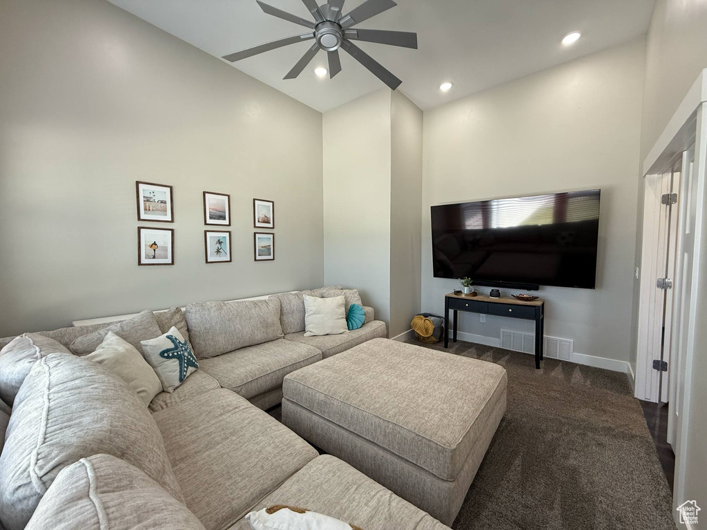 Living room with a ceiling fan, dark carpet, high vaulted ceiling, recessed lighting, and baseboards