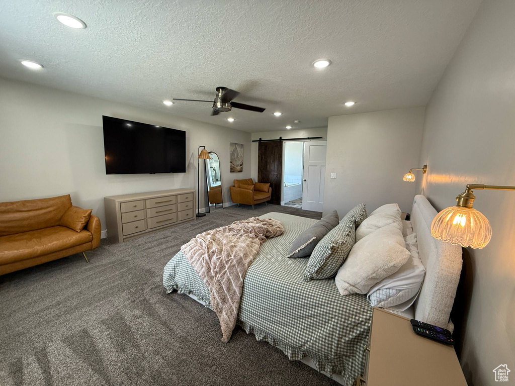 Carpeted bedroom featuring a barn door, recessed lighting, a textured ceiling, and a ceiling fan