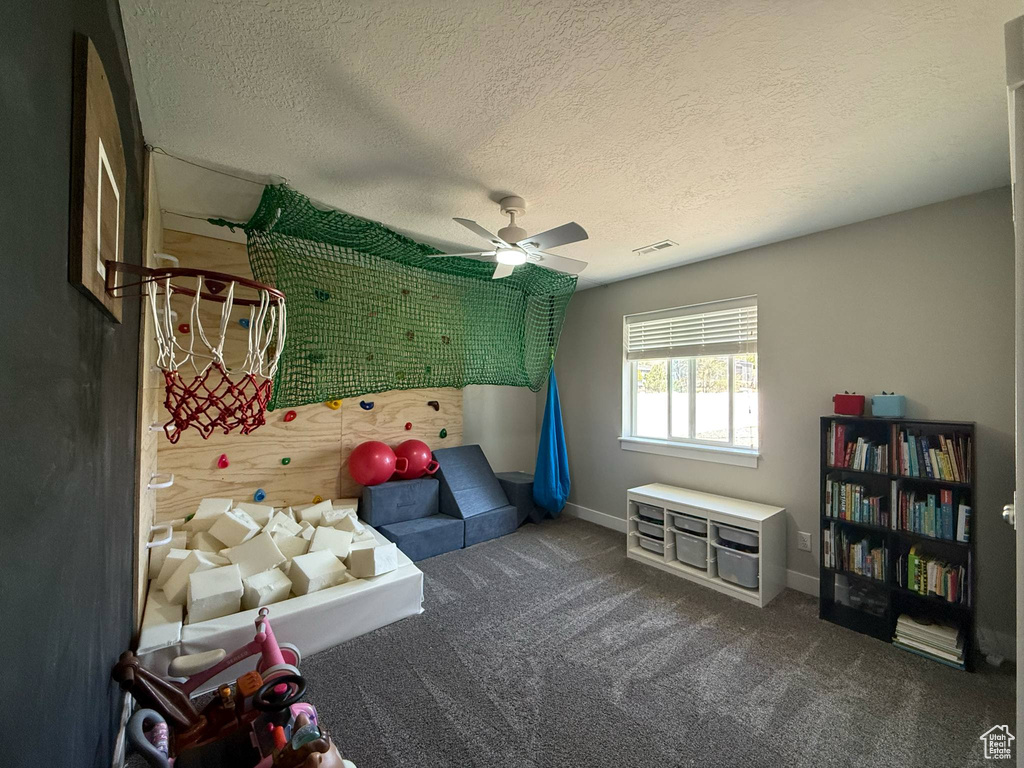 Game room featuring carpet floors, a ceiling fan, baseboards, and a textured ceiling