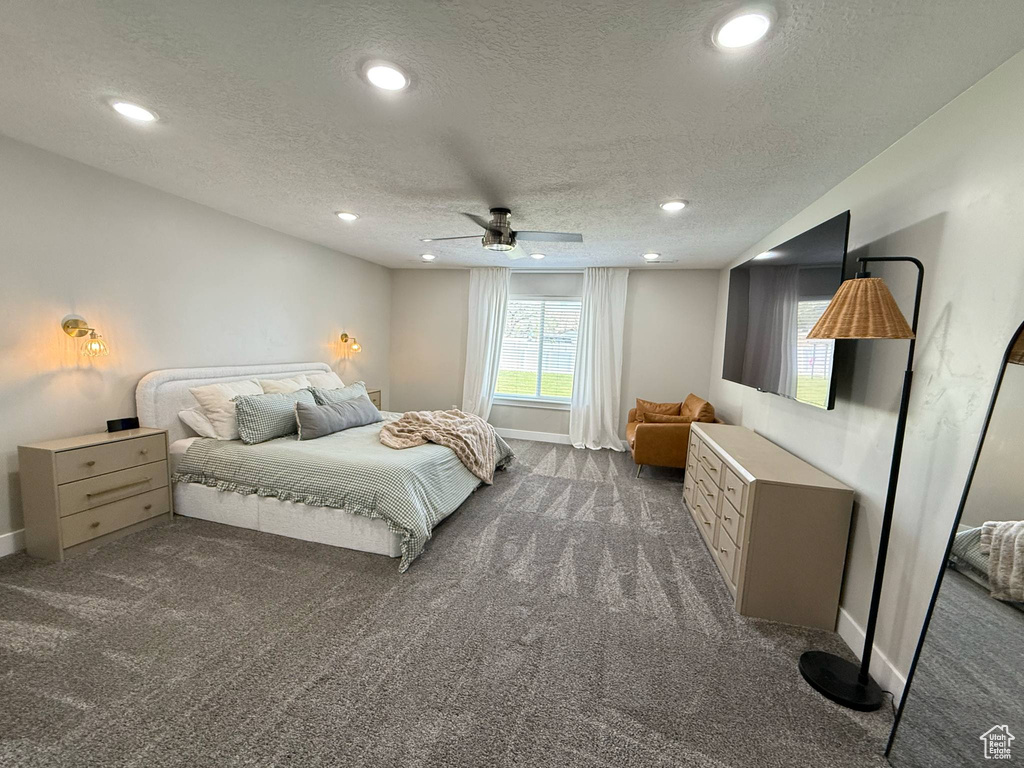 Bedroom with dark carpet, a textured ceiling, baseboards, recessed lighting, and a ceiling fan