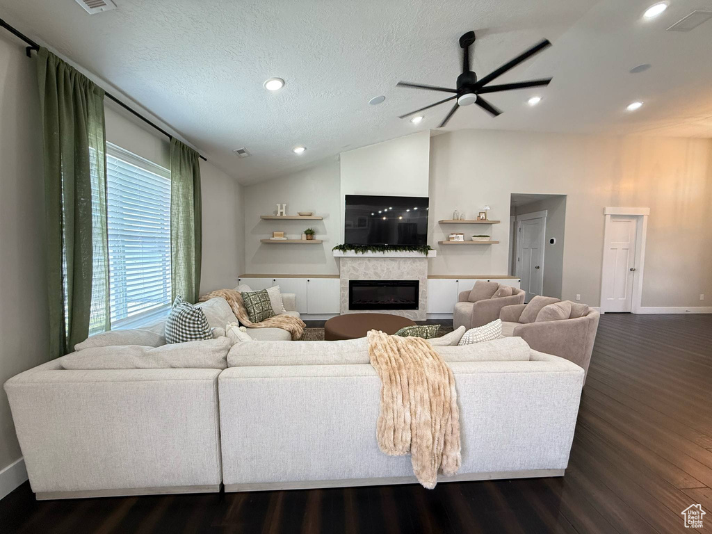 Living room with ceiling fan, dark wood-style floors, a glass covered fireplace, baseboards, and recessed lighting