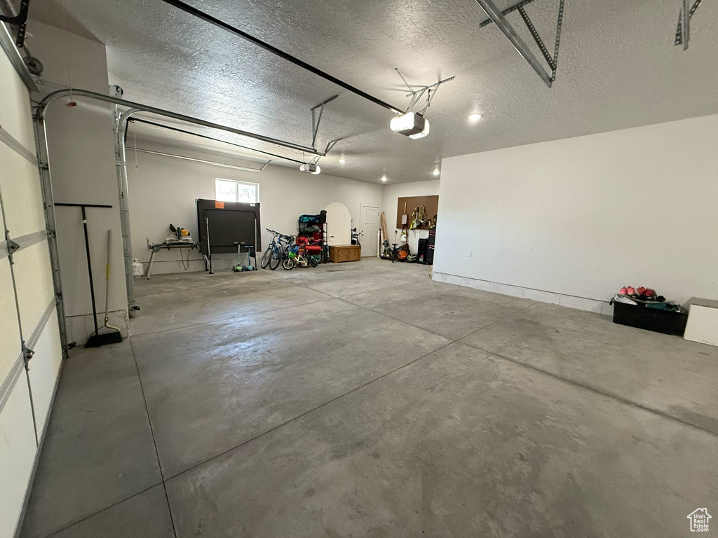 Garage featuring a garage door opener and baseboards
